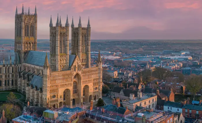 An aerial view of Lincoln Cathedral with text layered on top saying 2027 NASGA International Tour, England, March 9-12, 2027